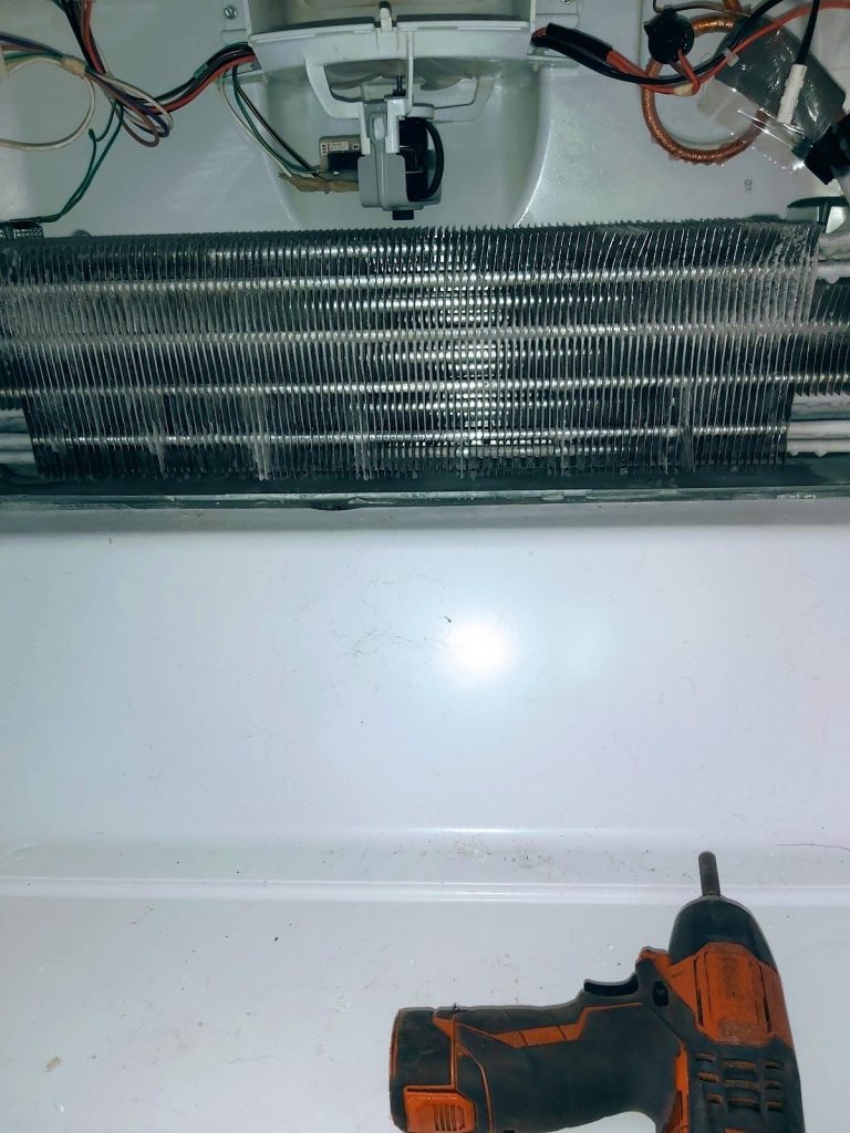 Refrigerator evaporator coil exposed during a fridge repair by Octopus Royal
