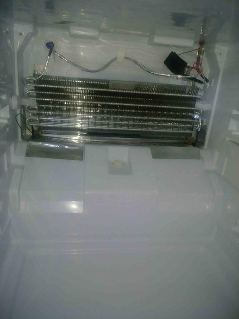 Refrigerator evaporator coil exposed during a fridge repair by Octopus Royal