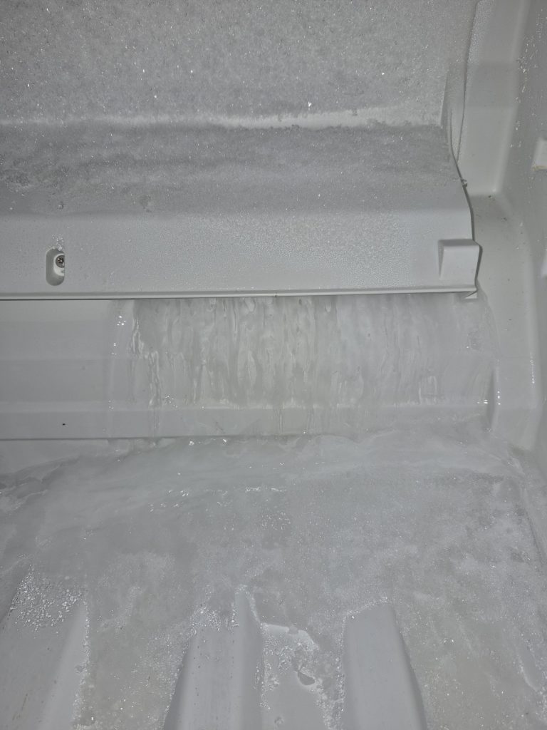 Thick ice build-up on the freezer floor and back wall of a Miele fridge, Toronto