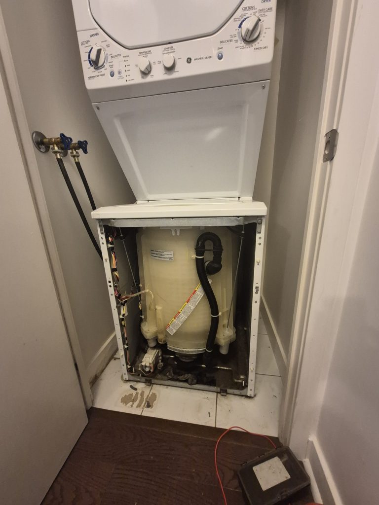 GE stacked laundry centre with the washer panel removed for drain pump replacement, Toronto