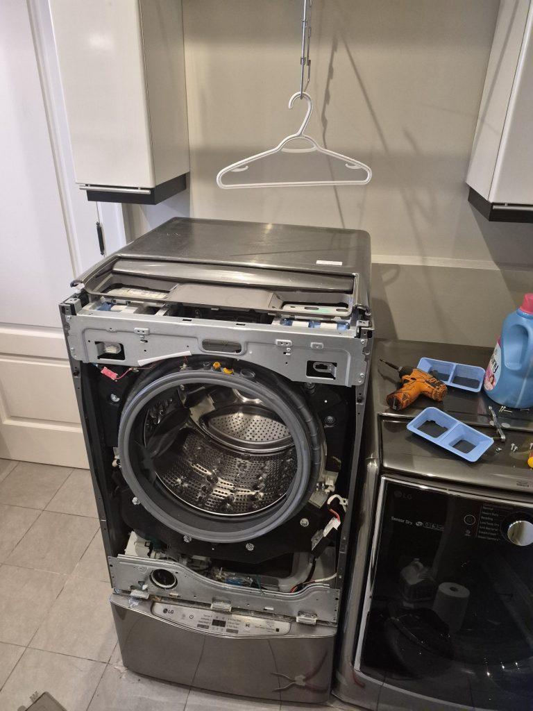 LG front-load washer with the front panel removed for door gasket replacement, North York