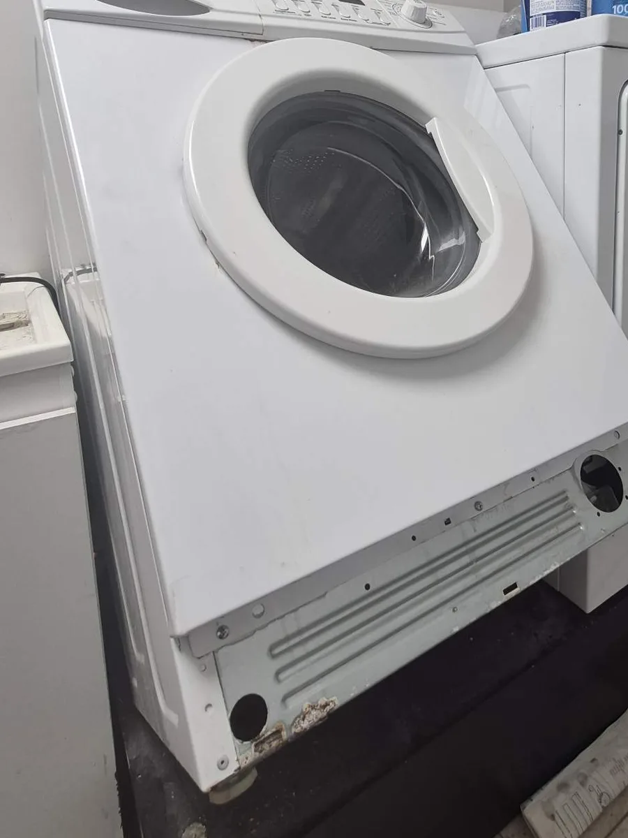 Maytag compact front-load washer with the front panel being removed