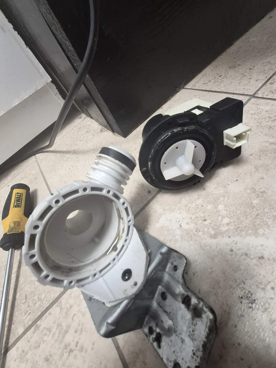 Old drain pump removed from a Maytag washer after sand damaged it