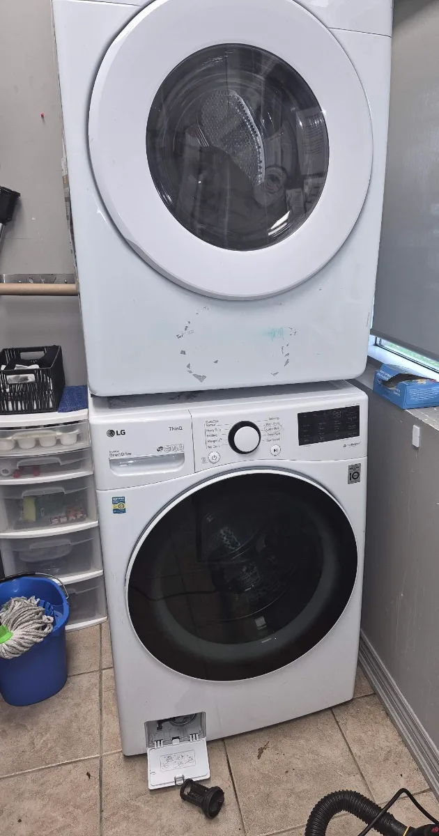 Samsung dryer secured on top of an LG washer with modified stacking brackets after maintenance