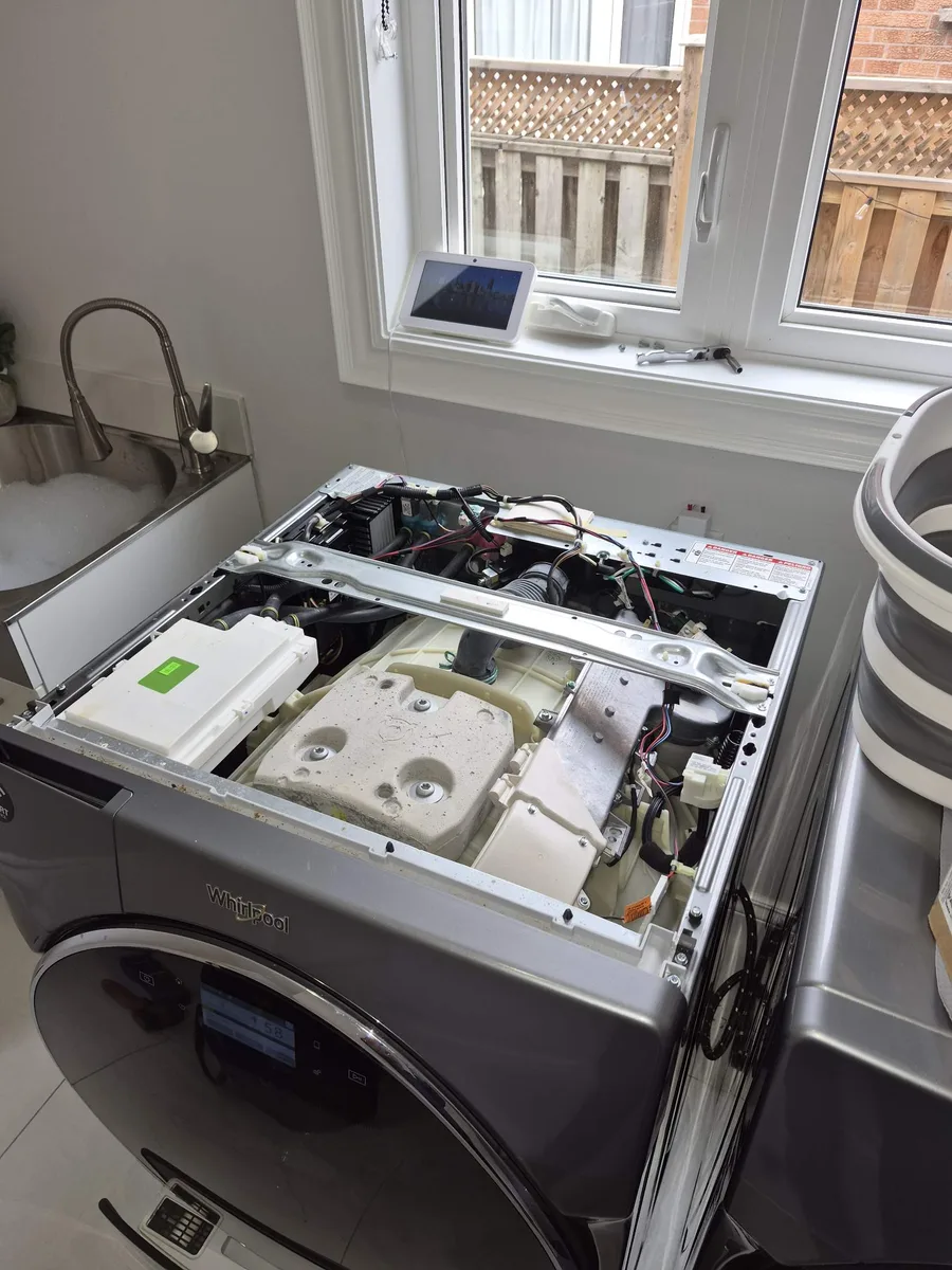 Whirlpool front-load washer with the top panel removed for an inlet valve repair